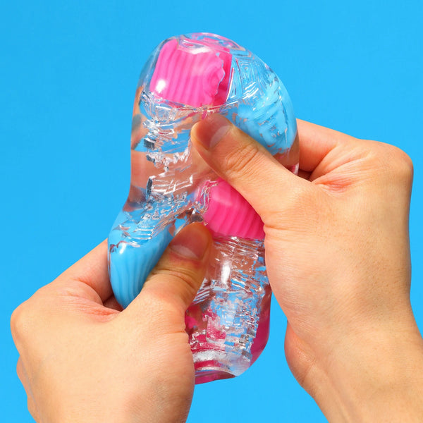 按壓 TENGA Bobble Crazy Cubes 飛機杯,強調柔軟彈性的材質。
